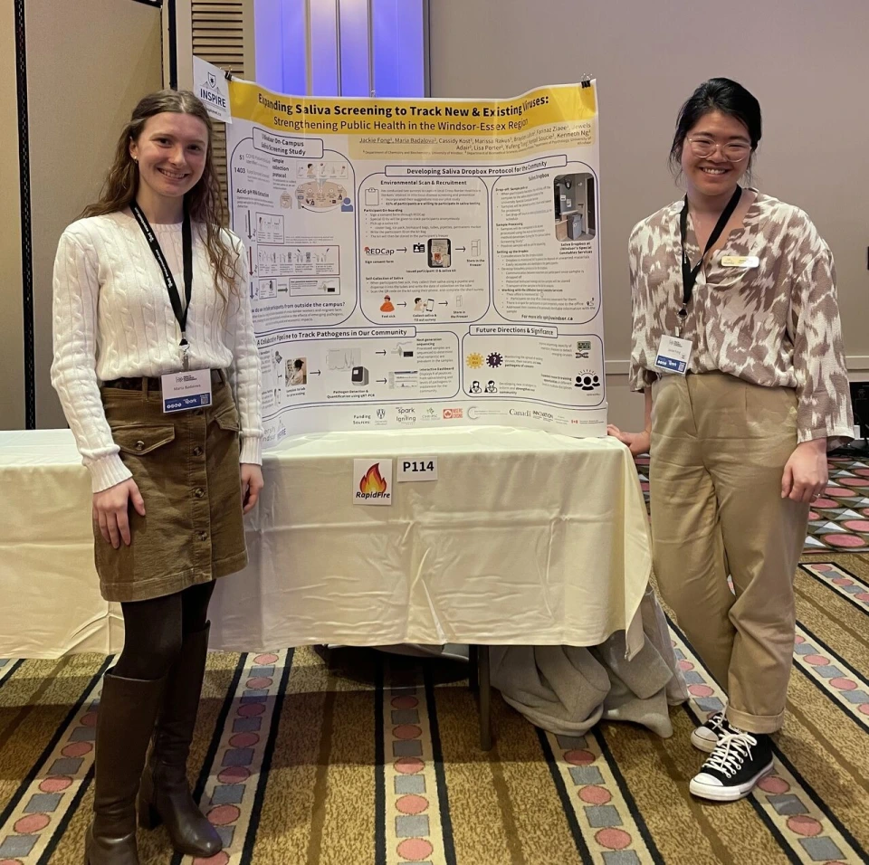 Maria Badalova and Jackie Fong standing next to their research poster titled, "Expanding Saliva Screening to Track New & Existing Viruses"